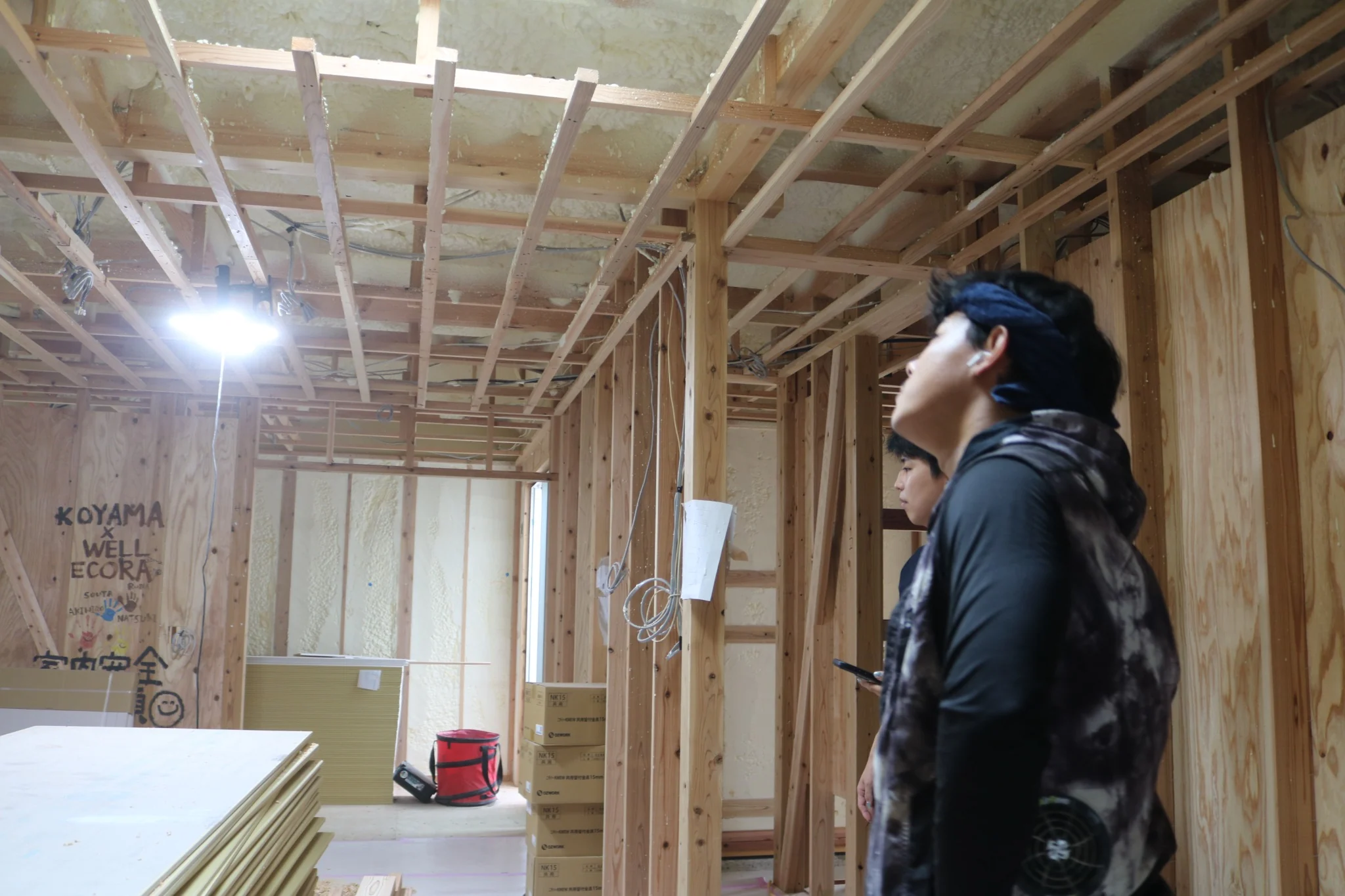 実際の住宅施工現場で複数の施工スタッフが全体の納まりを確認する様子