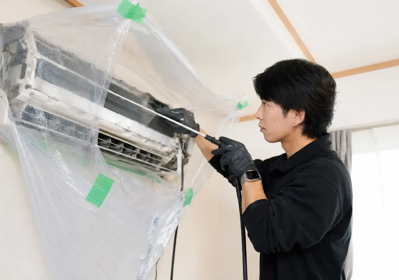 周辺を養生したClear Linkのエアコン内部洗浄 周辺を養生してエアコン内部を洗浄するClear Linkスタッフ