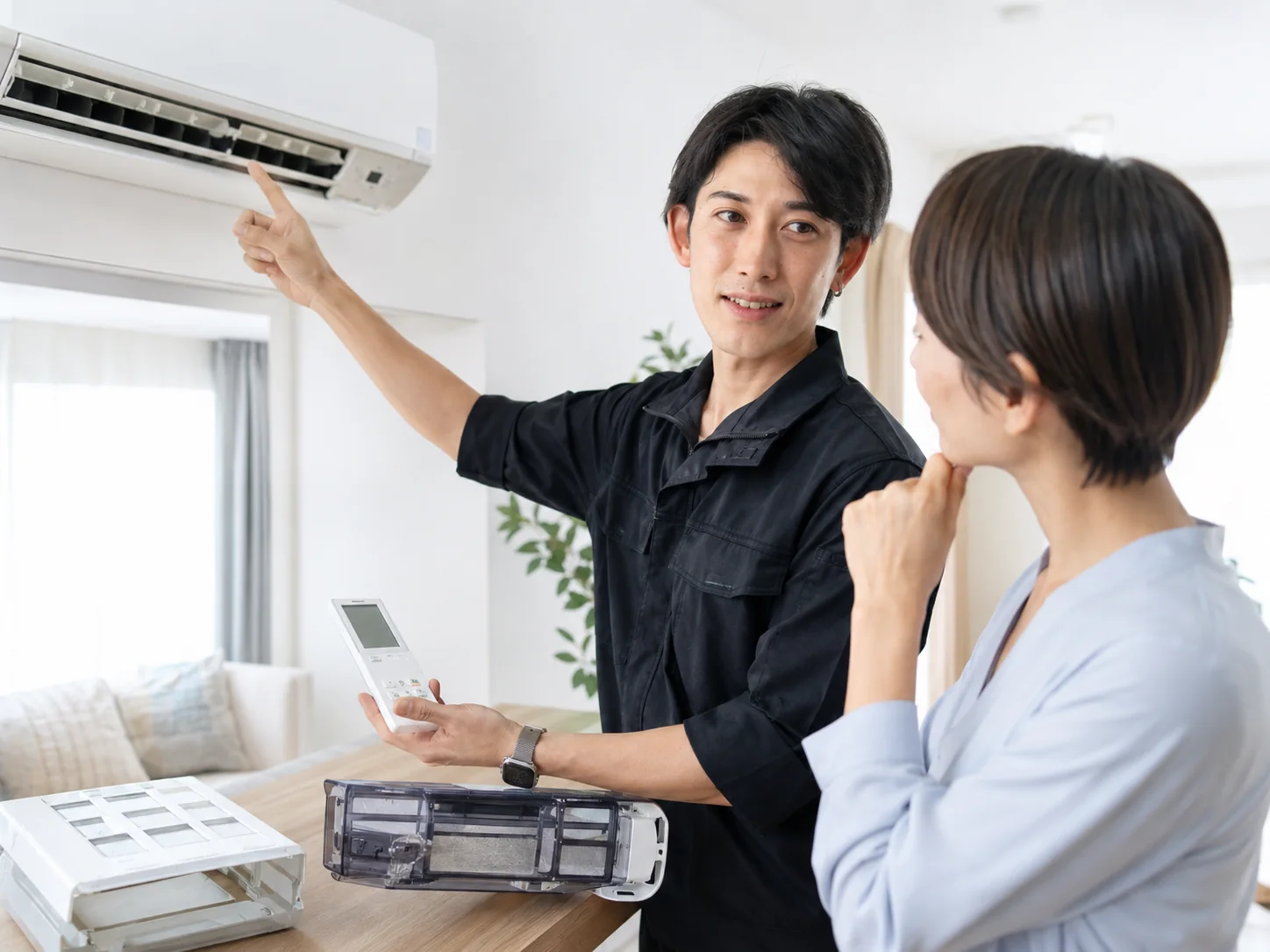 お掃除機能付きエアコンの型番やリモコンをお客様へ説明するサービスイメージ