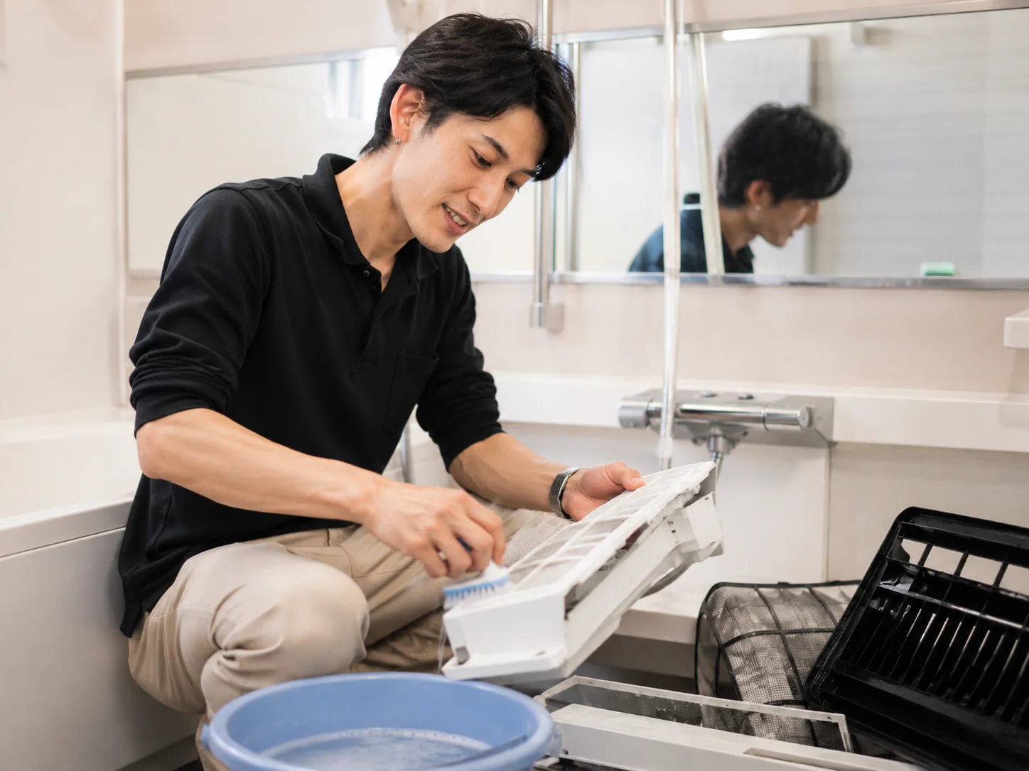 お掃除機能付きエアコンから取り外したフィルターや外装部品を洗浄する作業イメージ
